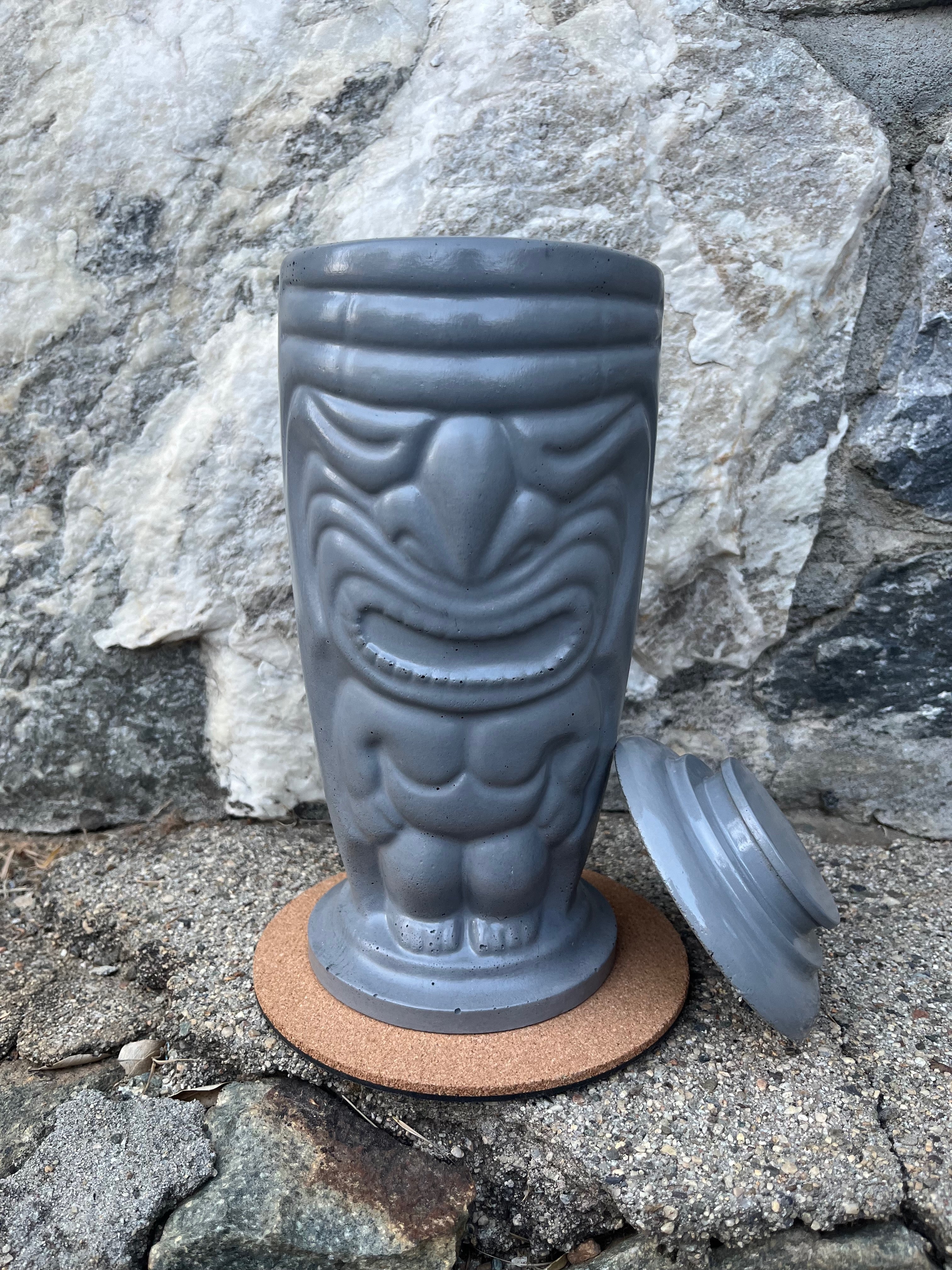 Rencarie Tiki tabletop fire pit with lid removed against a stone wall
