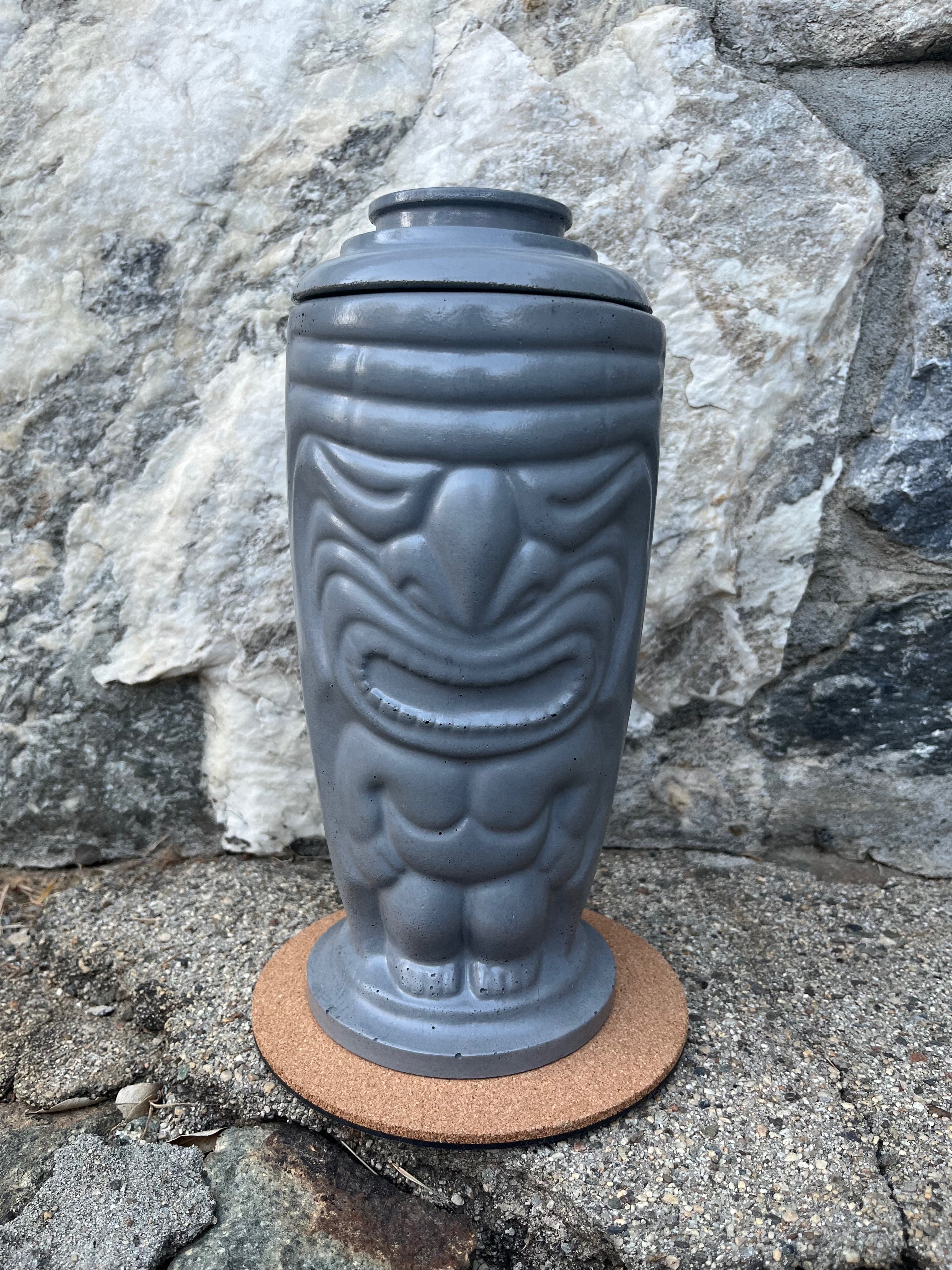 Rencarie Tiki tabletop fire pit with lid on against a stone wall